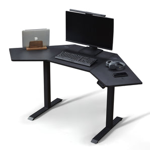 KOWO K314 corner sit stand desk in black colour with laptop and pc monitor on the tabletop. It offers large work area for both home office setp and gaming setup.