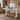 White adjustable desk with laptop, monitor, and keyboard in a home office setting.